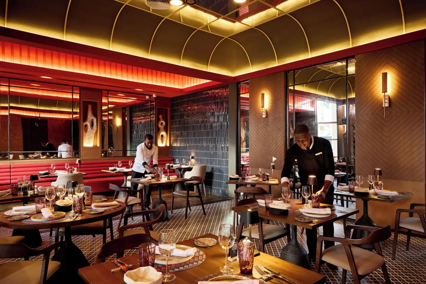 Modern restaurant dining room with arched ceiling lights at Hotel Riu Palace Bavaro.