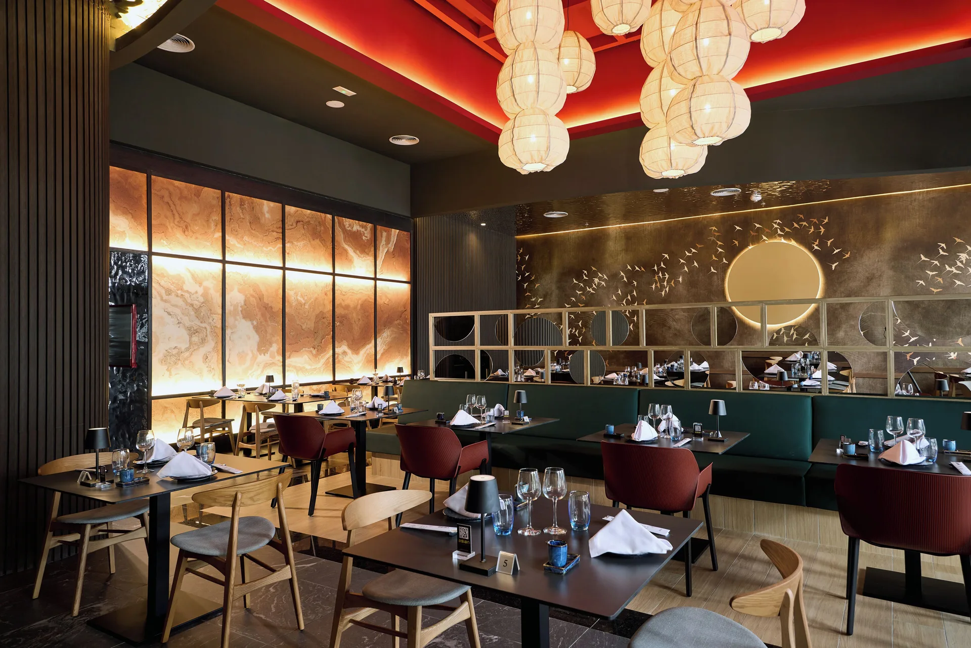 Asian-style dining room with lanterns and set tables at Hotel Riu Palace Bavaro.