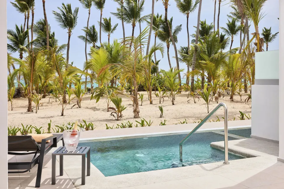 Elite Club Swim-up Suite pool terrace with loungers and palms at Hotel Riu Palace Bavaro.