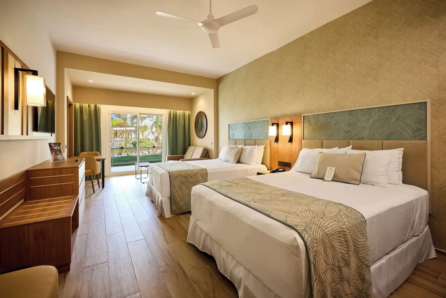 Junior Suite with two beds and balcony doors at Hotel Riu Palace Bavaro.