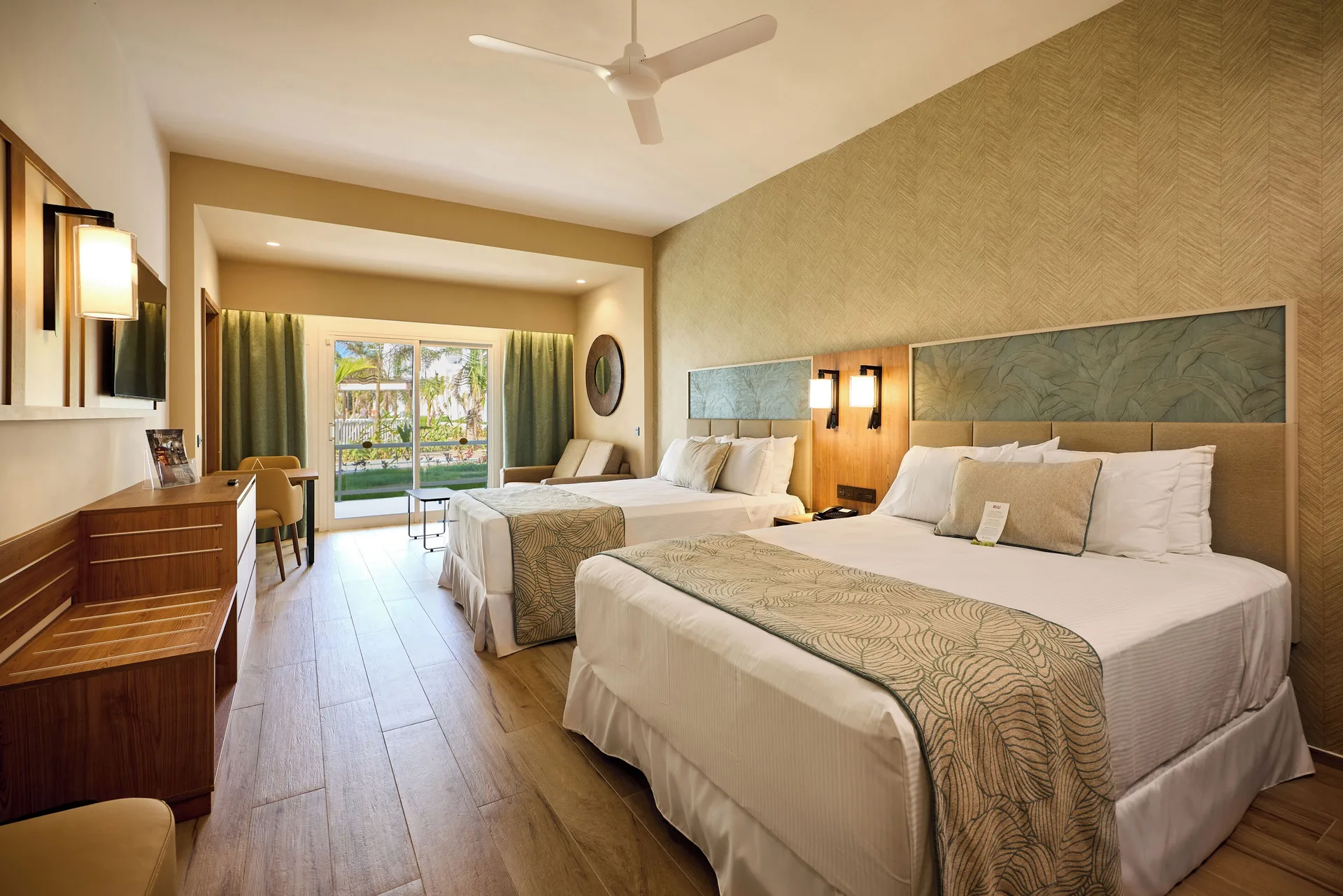 Junior Suite with two beds and balcony doors at Hotel Riu Palace Bavaro.