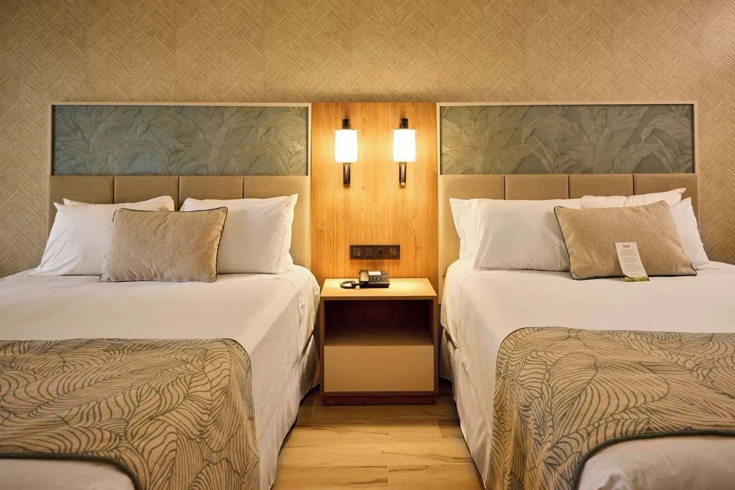 Two beds with shared nightstand in a Junior Suite at Hotel Riu Palace Bavaro.