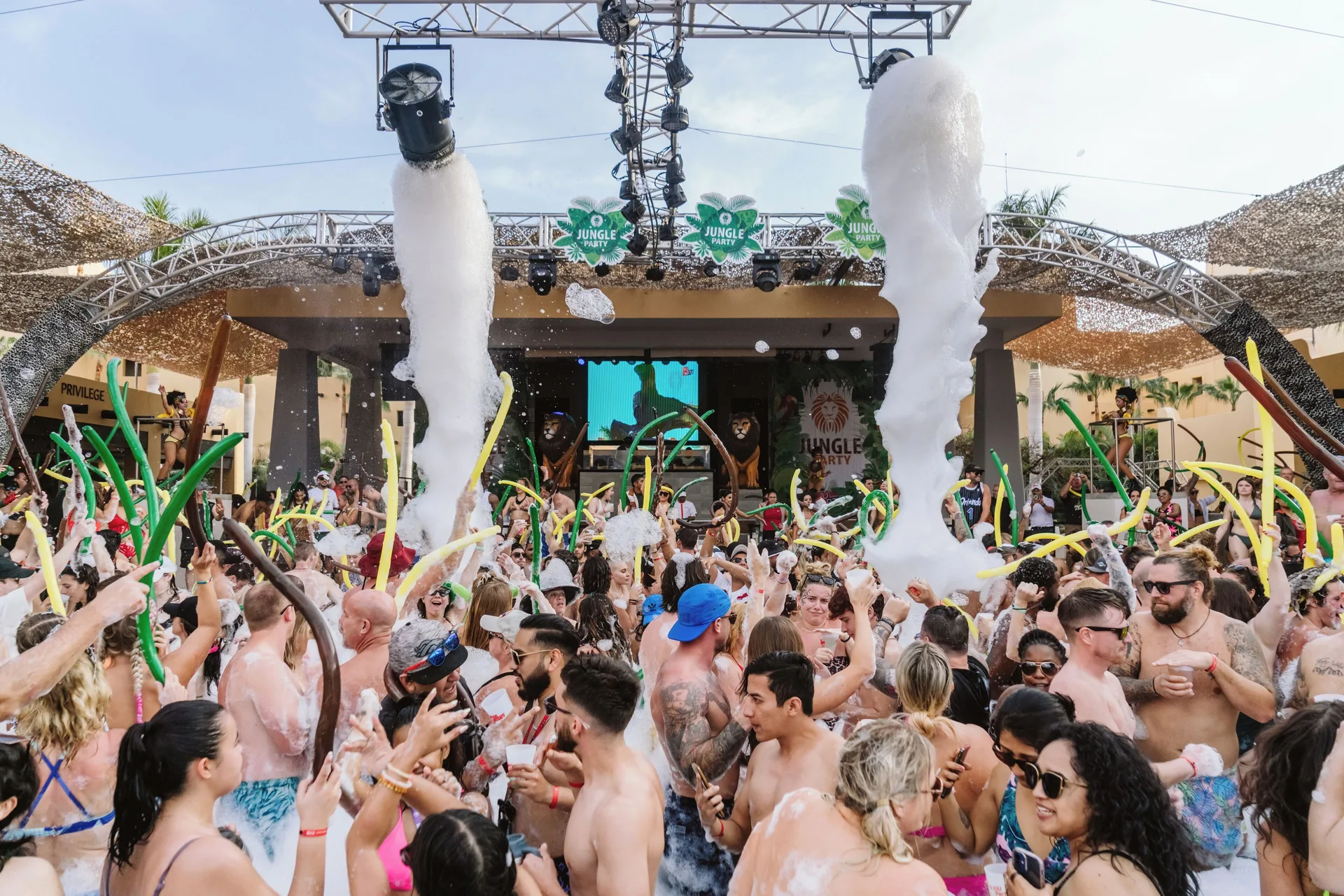 Large crowd at a daytime foam pool party at Hotel Riu Palace Cabo San Lucas.