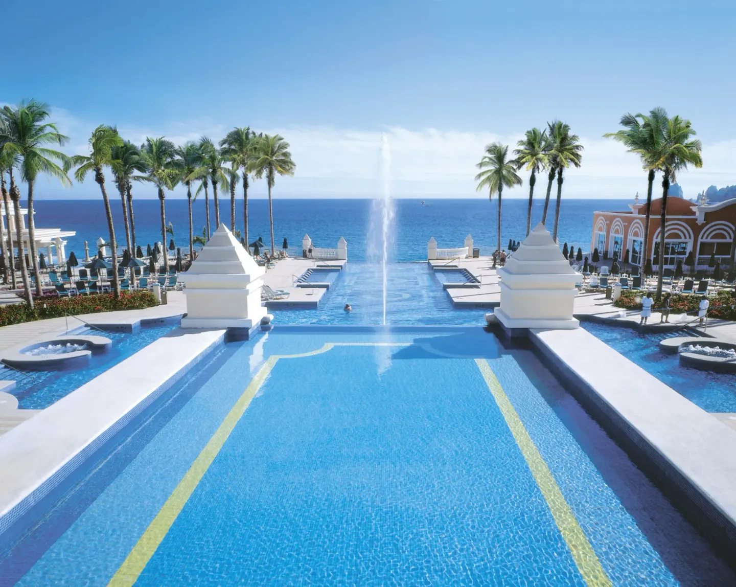 Long infinity-style pool with a central fountain at Hotel Riu Palace Cabo San Lucas.