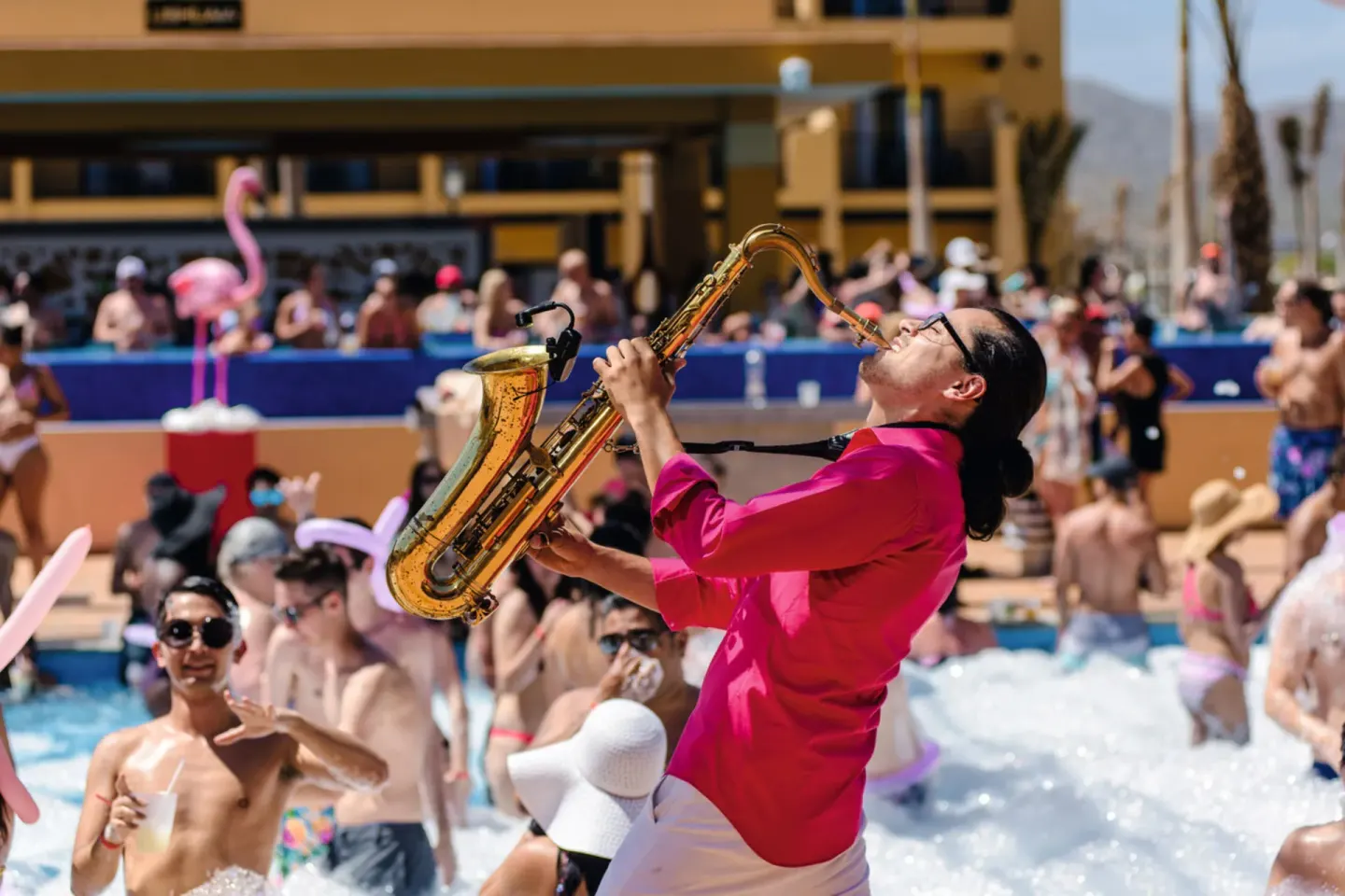 Saxophonist performing in a lively pool party at Hotel Riu Palace Cabo San Lucas.