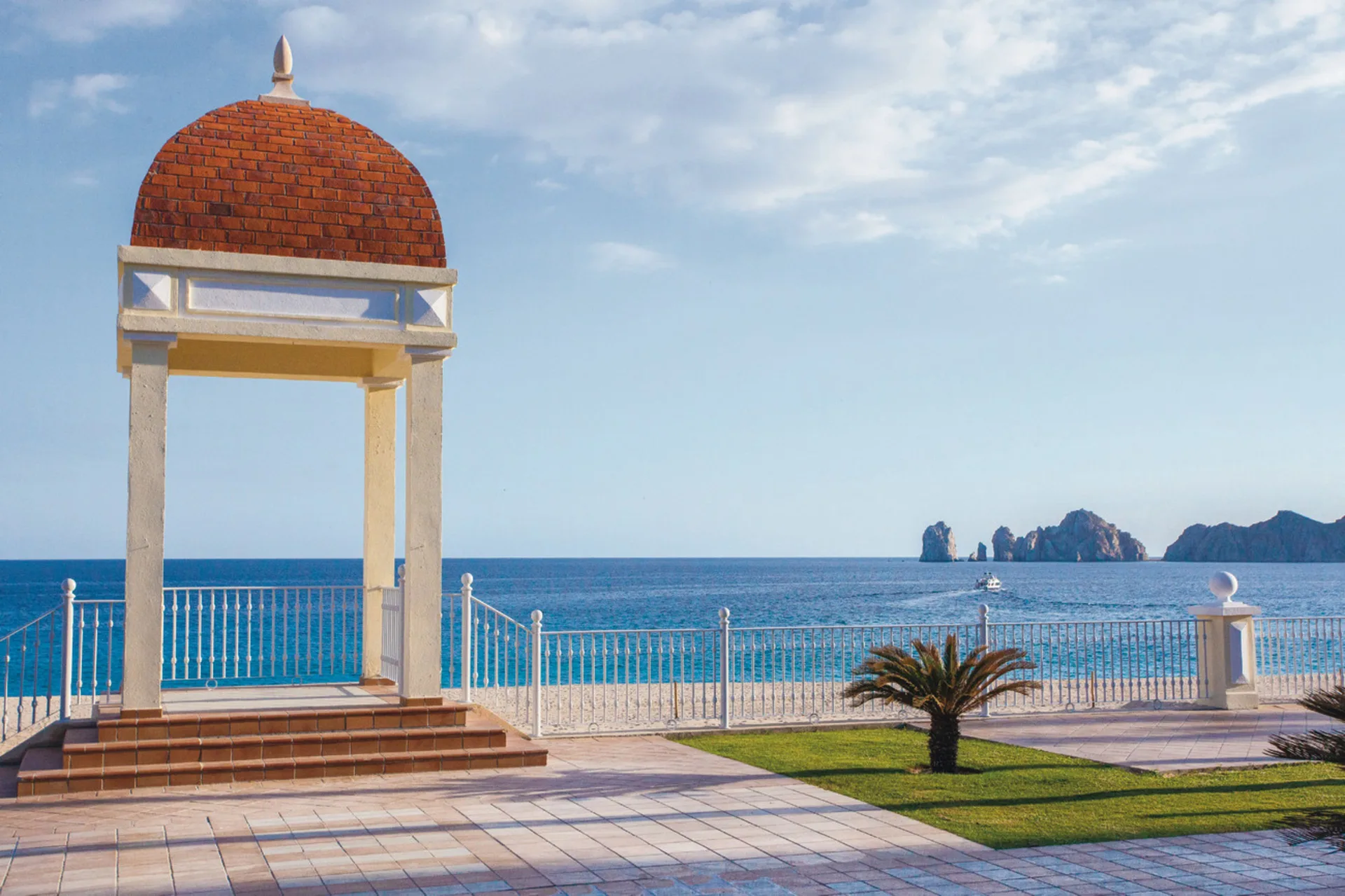 Domed seaside gazebo with ocean and rock formations beyond at Hotel Riu Palace Cabo San Lucas.