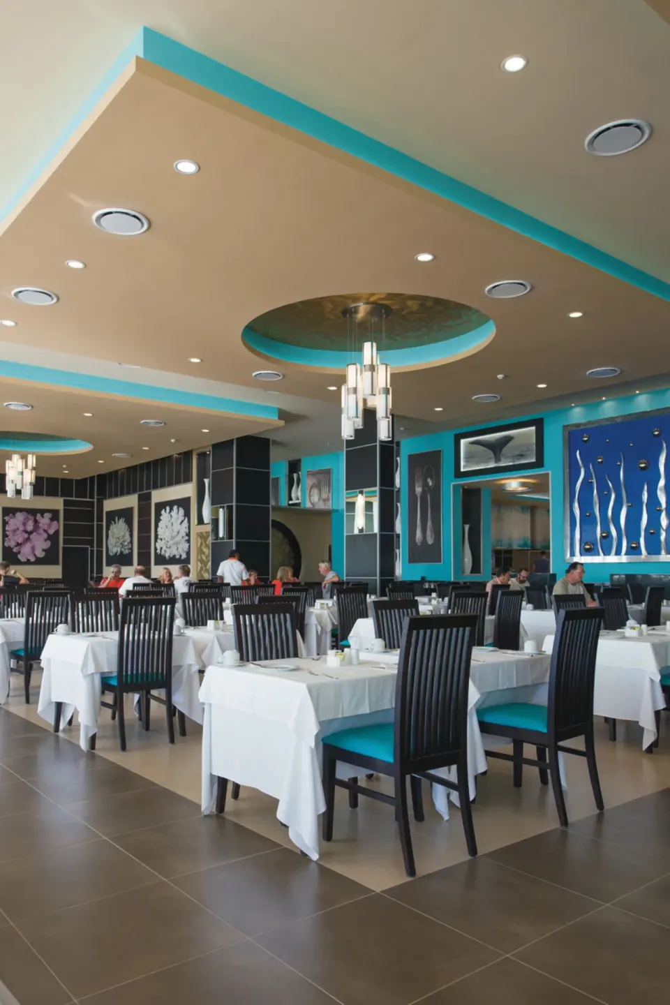 Bright dining room with turquoise accents at Hotel Riu Palace Cabo San Lucas.