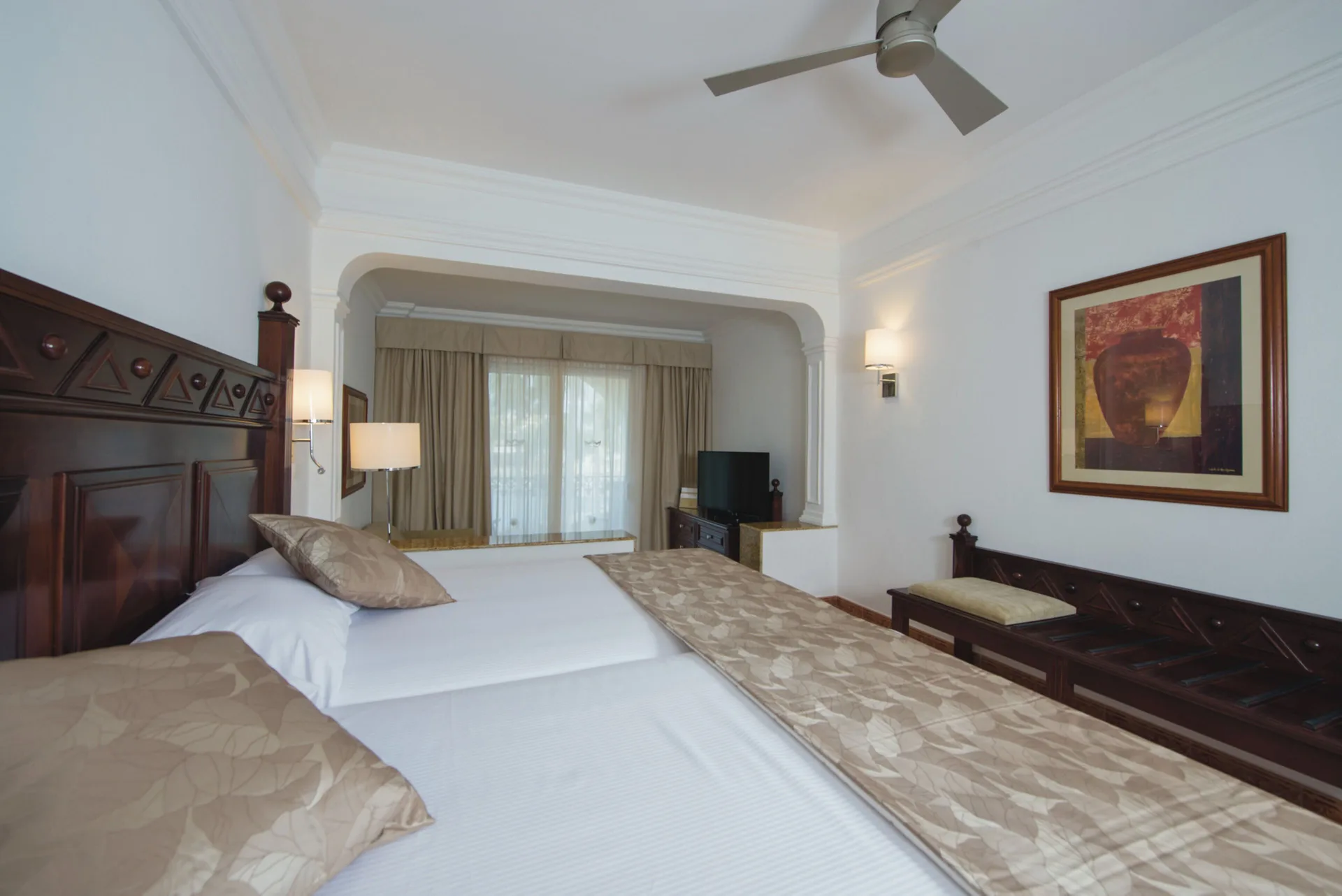 Junior Suite with two beds and sitting bench at Hotel Riu Palace Cabo San Lucas.