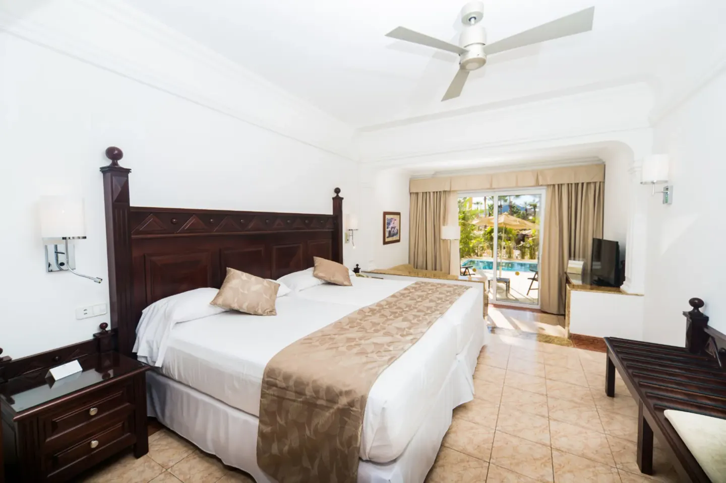 Junior Suite Swim Up bedroom with king bed and pool-view terrace at Hotel Riu Palace Cabo San Lucas.