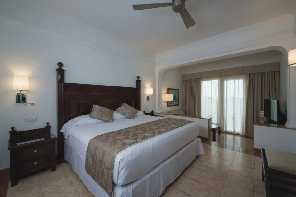 Junior Suite bed and balcony doors at Hotel Riu Palace Cabo San Lucas.