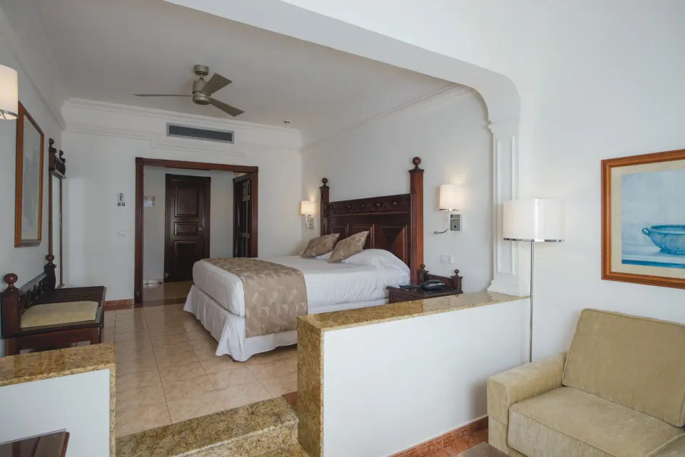 Junior Suite sitting area and bed at Hotel Riu Palace Cabo San Lucas.