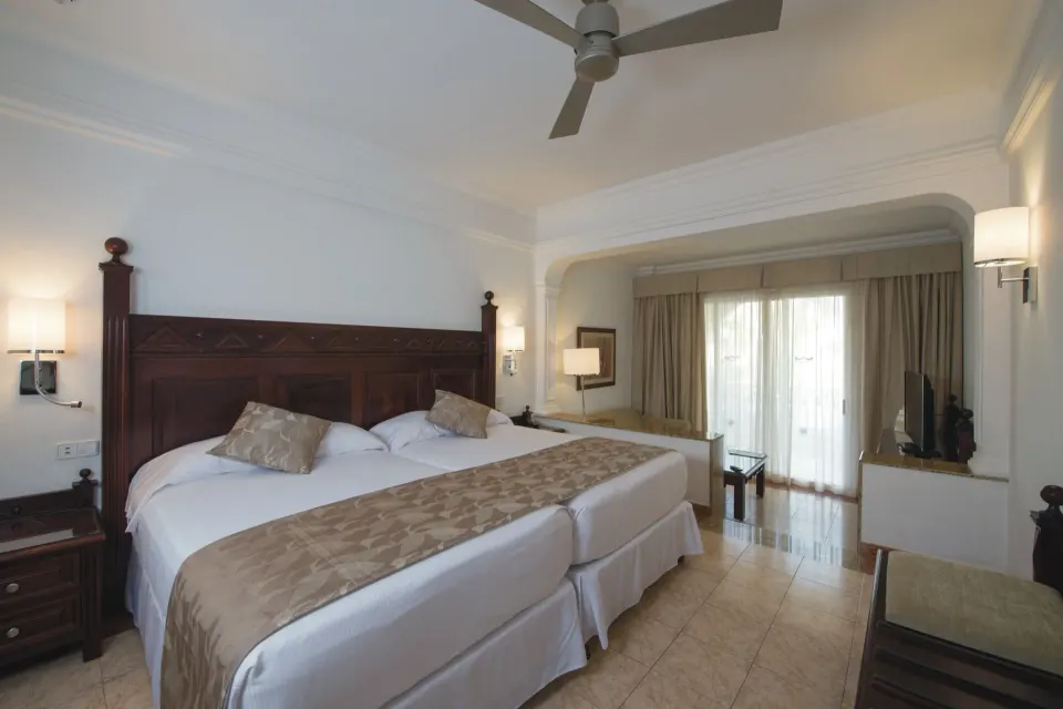 Junior Suite twin beds and TV at Hotel Riu Palace Cabo San Lucas.