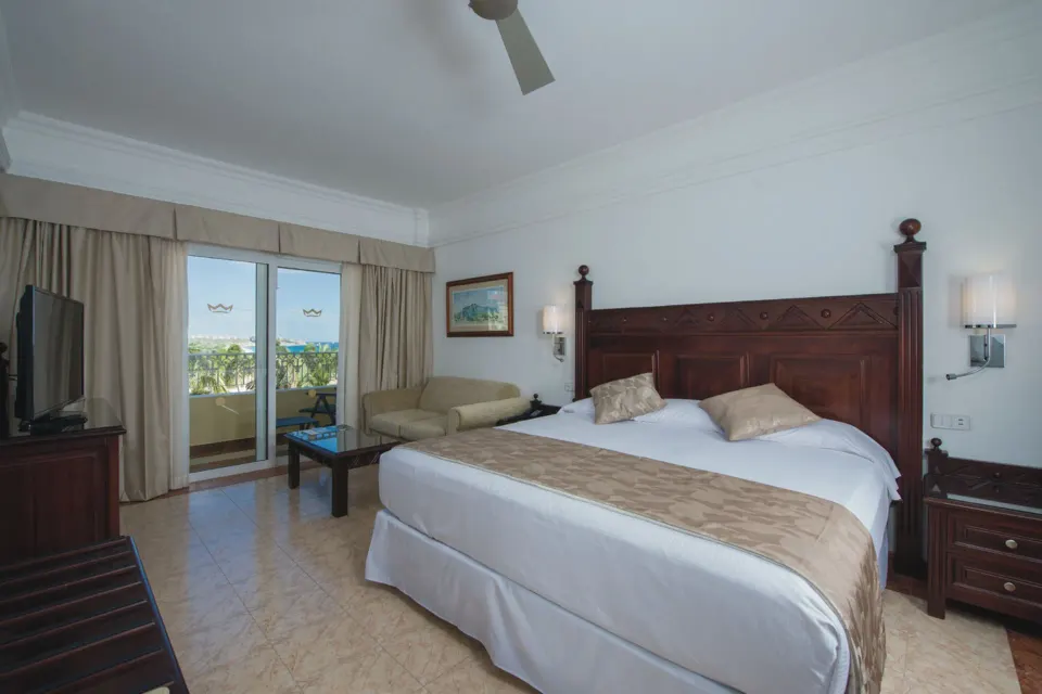 Ocean View room with king bed, sofa, and balcony at Hotel Riu Palace Cabo San Lucas.
