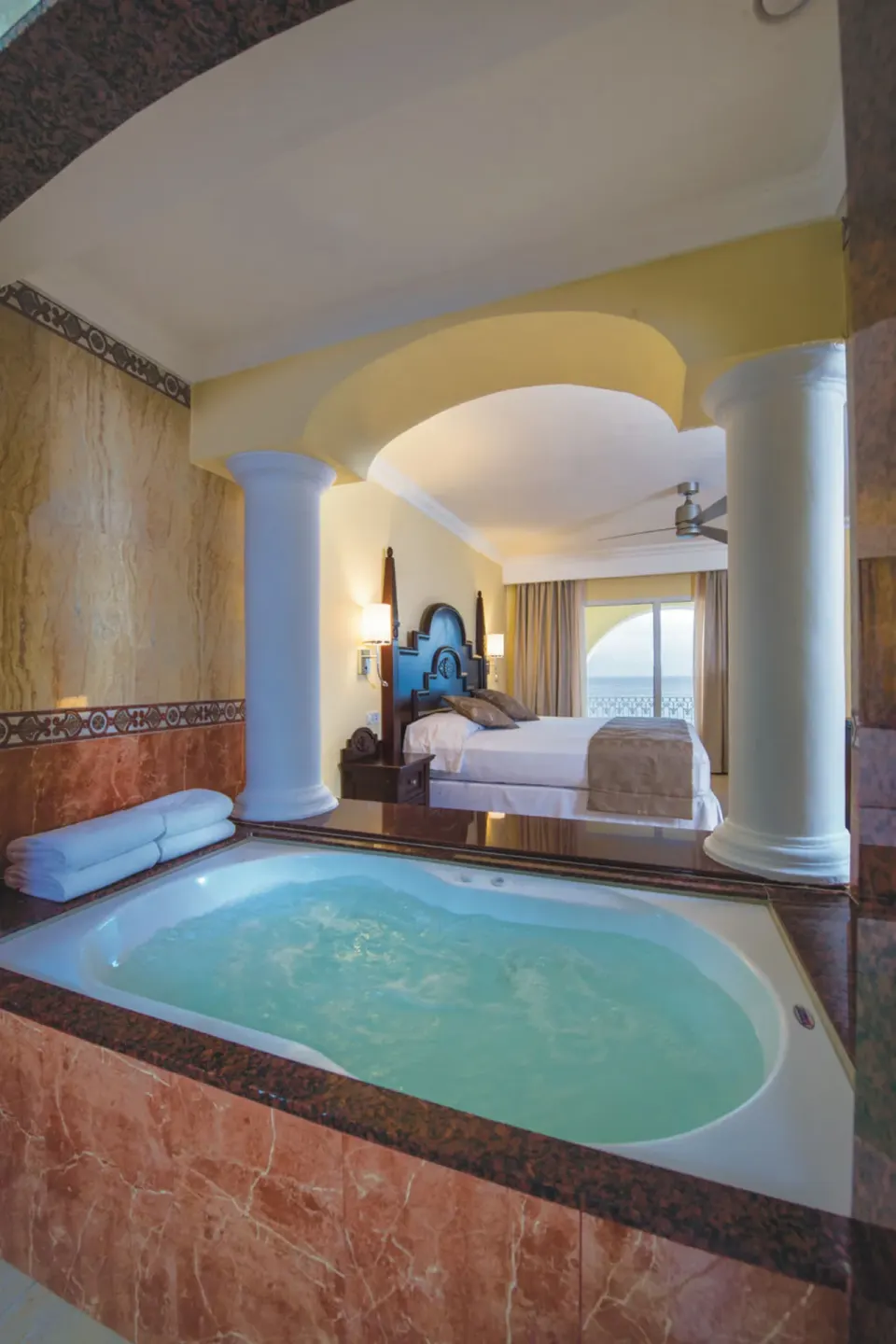 In-room jetted tub with bedroom beyond in a suite at Hotel Riu Palace Cabo San Lucas.