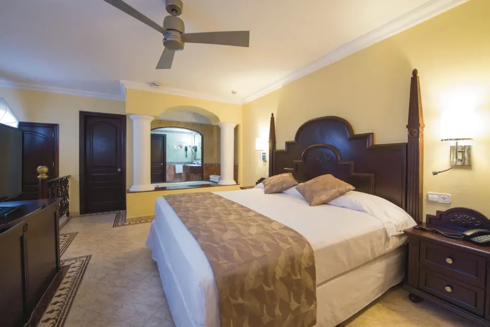 Suite bedroom with king bed and jetted tub alcove at Hotel Riu Palace Cabo San Lucas.