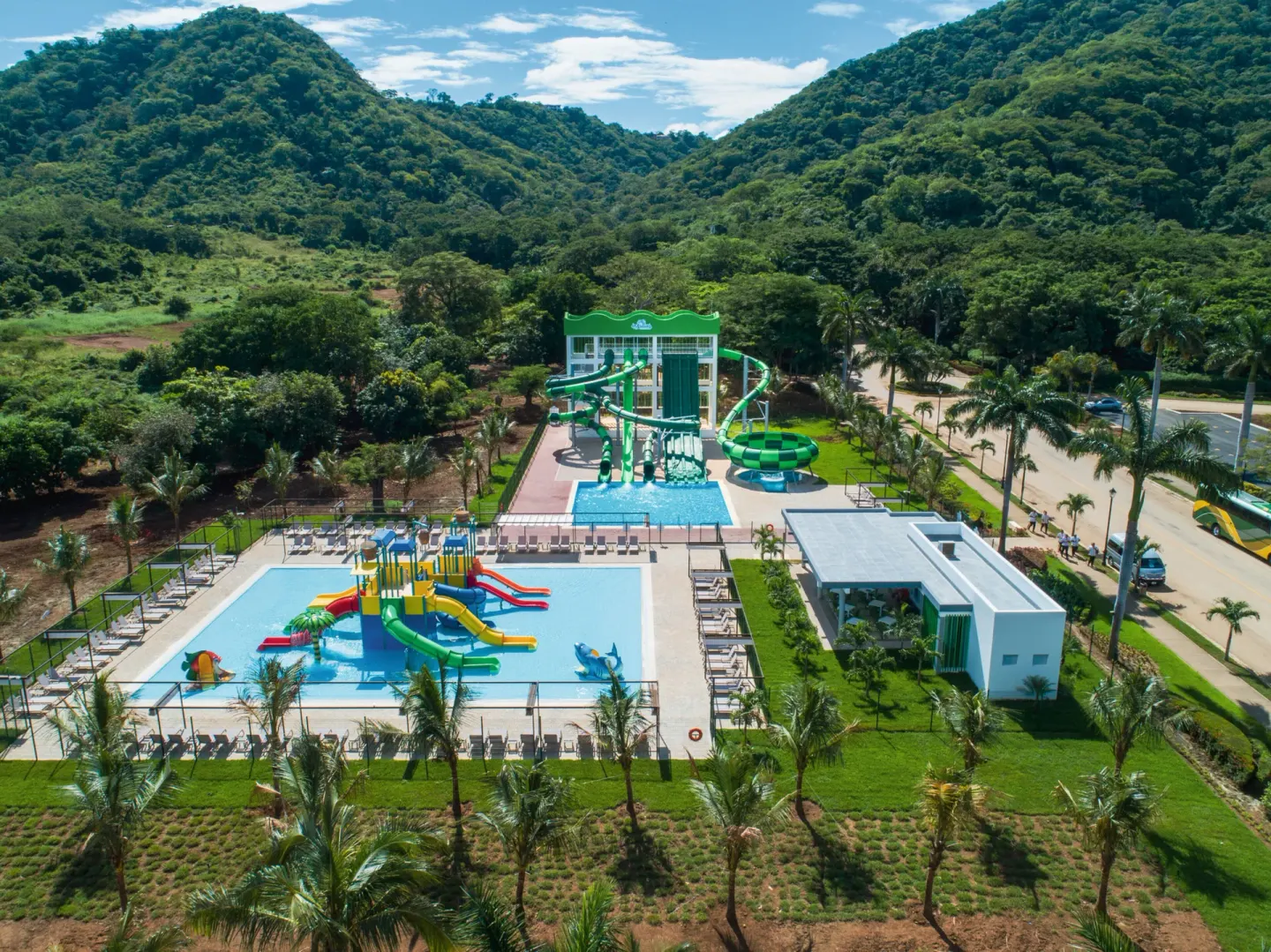 Aerial water park view with forested hills at Hotel Riu Palace Costa Rica.