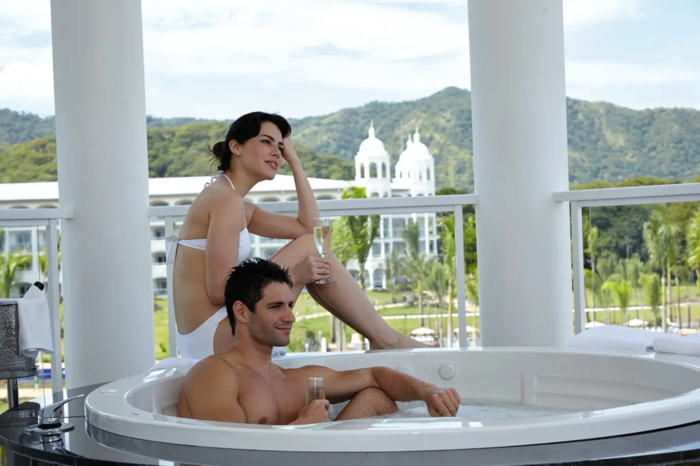 Couple relaxing in a balcony whirlpool tub at Hotel Riu Palace Costa Rica.