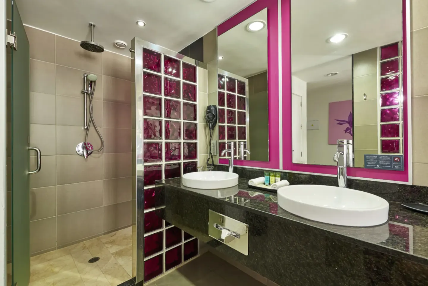 Guest bathroom with double vessel sinks and walk-in shower at Hotel Riu Palace Costa Rica.