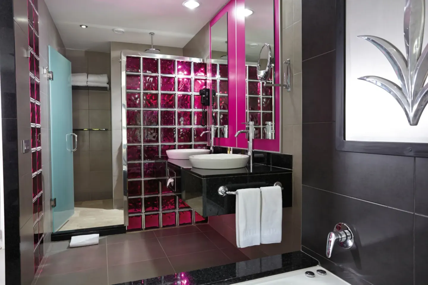 Guest room bathroom with vessel sink and glass-block shower at Hotel Riu Palace Costa Rica.