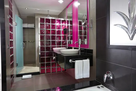 Guest room bathroom with vessel sink and glass-block shower at Hotel Riu Palace Costa Rica.