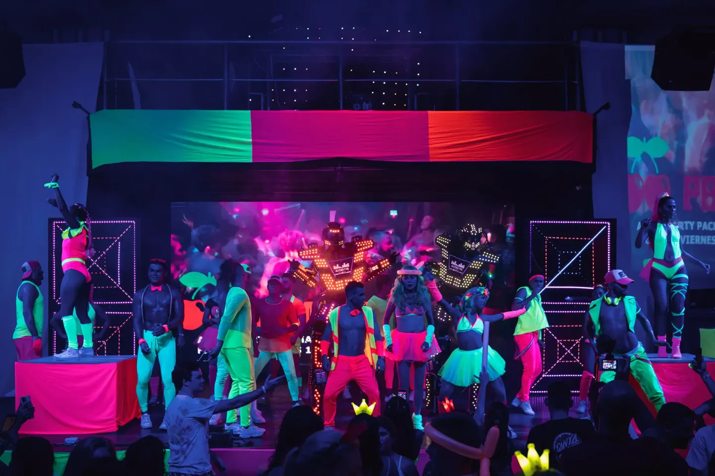A neon stage show with dancers and LED robots fills the venue at Hotel Riu Palace Costa Rica.