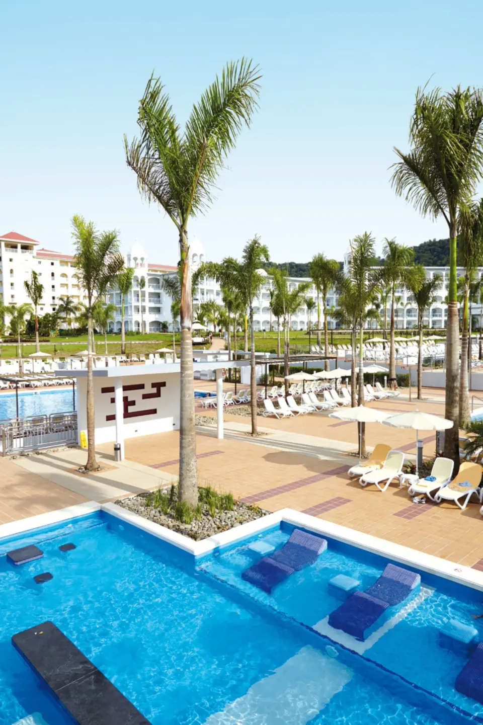 Overhead view of pools, palms, and loungers at Hotel Riu Palace Costa Rica.