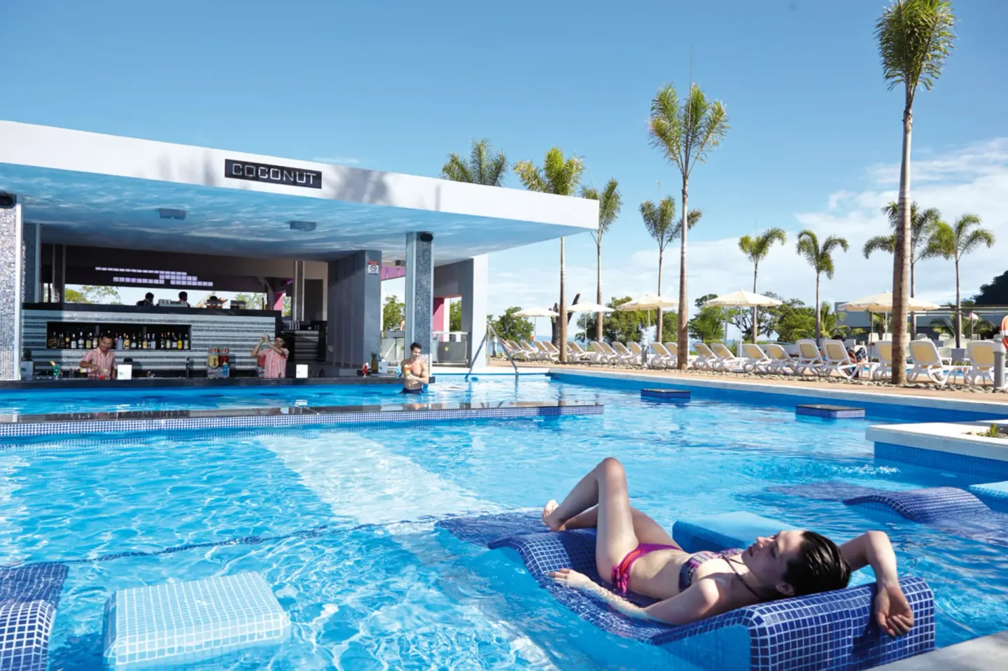 Swim-up pool bar and in-water loungers at Hotel Riu Palace Costa Rica.
