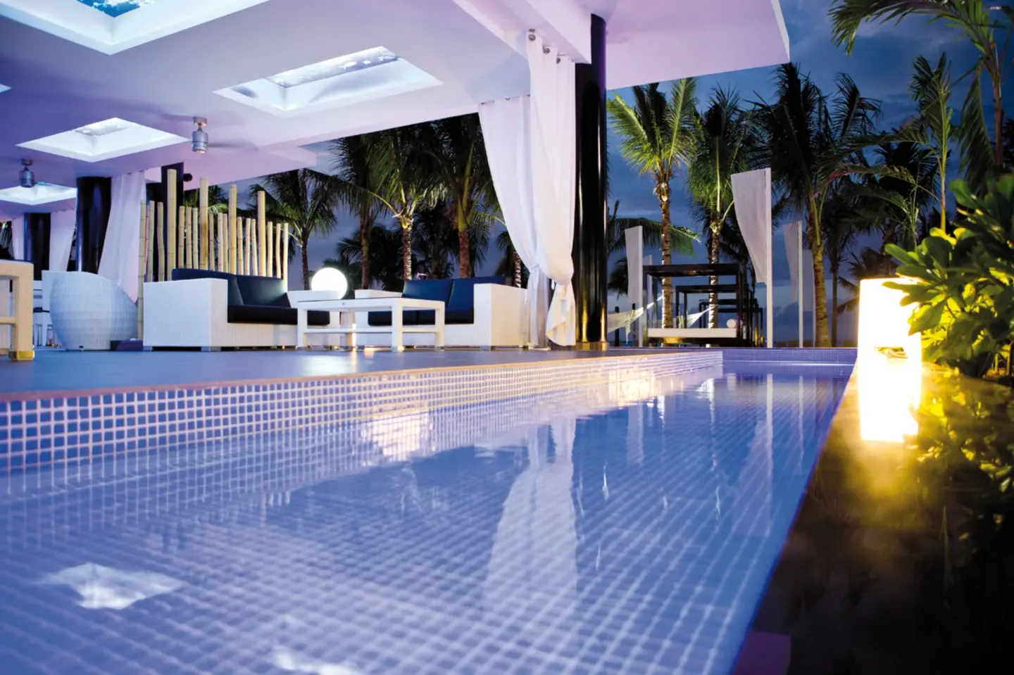 Evening terrace lounge beside a reflective pool at Hotel Riu Palace Jamaica.