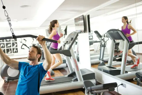 Guests use treadmills and strength equipment in the fitness room at Hotel Riu Palace Jamaica.