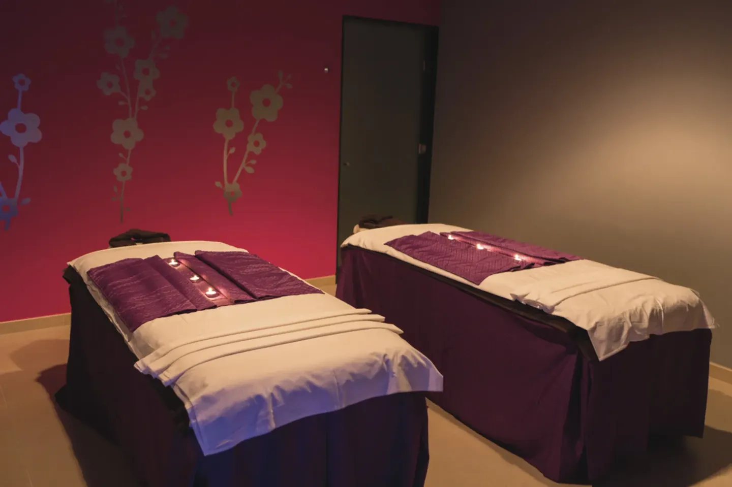 Two prepared spa treatment beds stand in a dim treatment room at Hotel Riu Palace Jamaica.