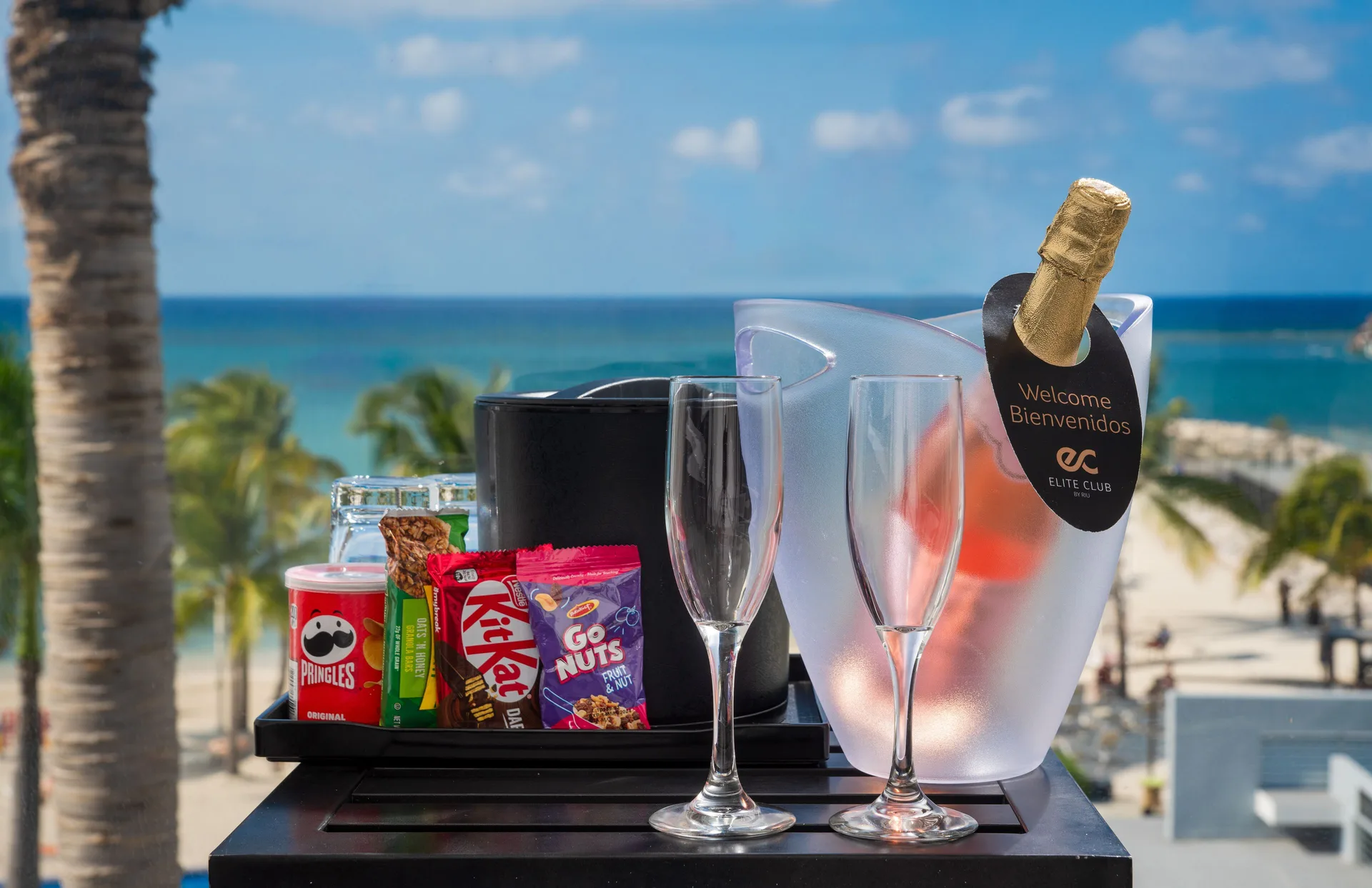 Welcome drinks, snacks, and glasses sit on a table with the sea beyond at Hotel Riu Palace Jamaica.
