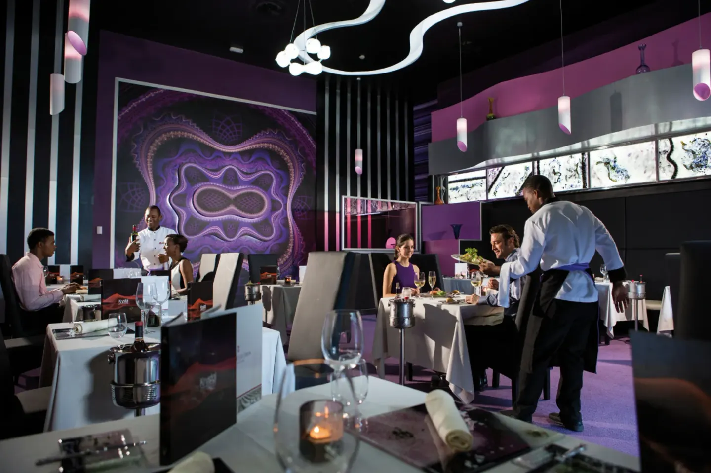 Purple-accented specialty dining room with guests at Hotel Riu Palace Jamaica.