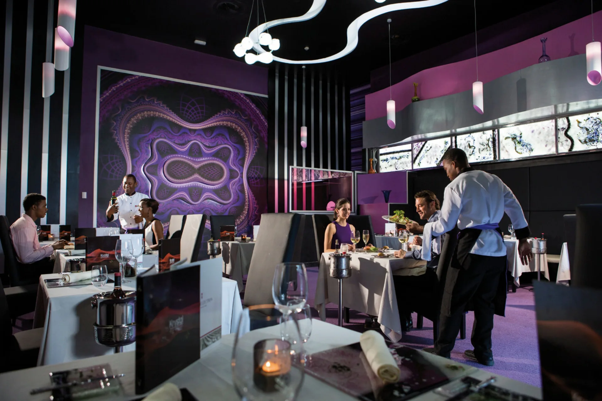 Purple-accented specialty dining room with guests at Hotel Riu Palace Jamaica.