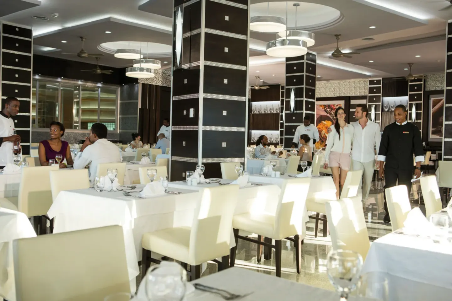 Bright white-tablecloth restaurant dining room at Hotel Riu Palace Jamaica.