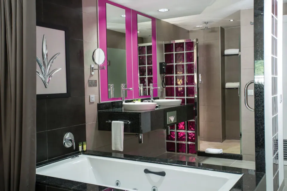 Junior Suite Garden View bathroom with tub, vanity and shower at Hotel Riu Palace Jamaica.