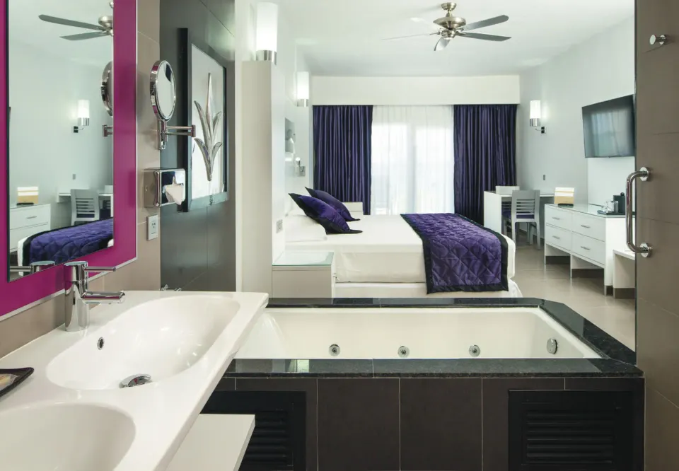 Junior Suite Garden View bathroom and bed area at Hotel Riu Palace Jamaica.