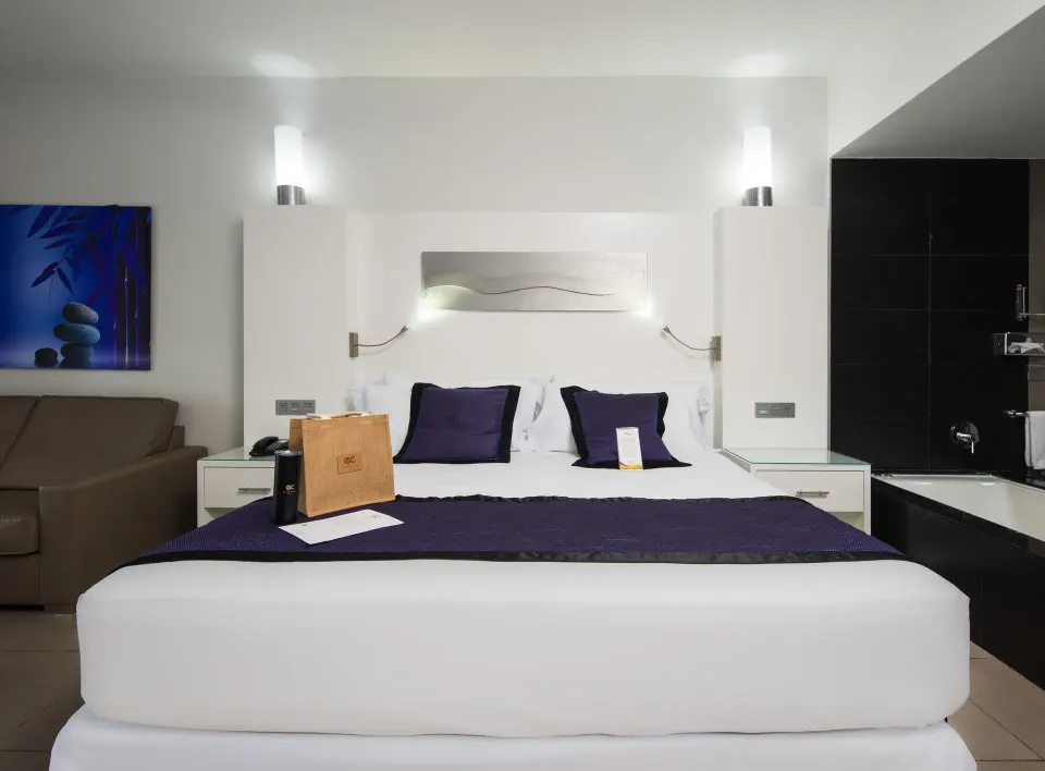 Oceanfront Junior Suite bed and open bathroom at Hotel Riu Palace Jamaica.
