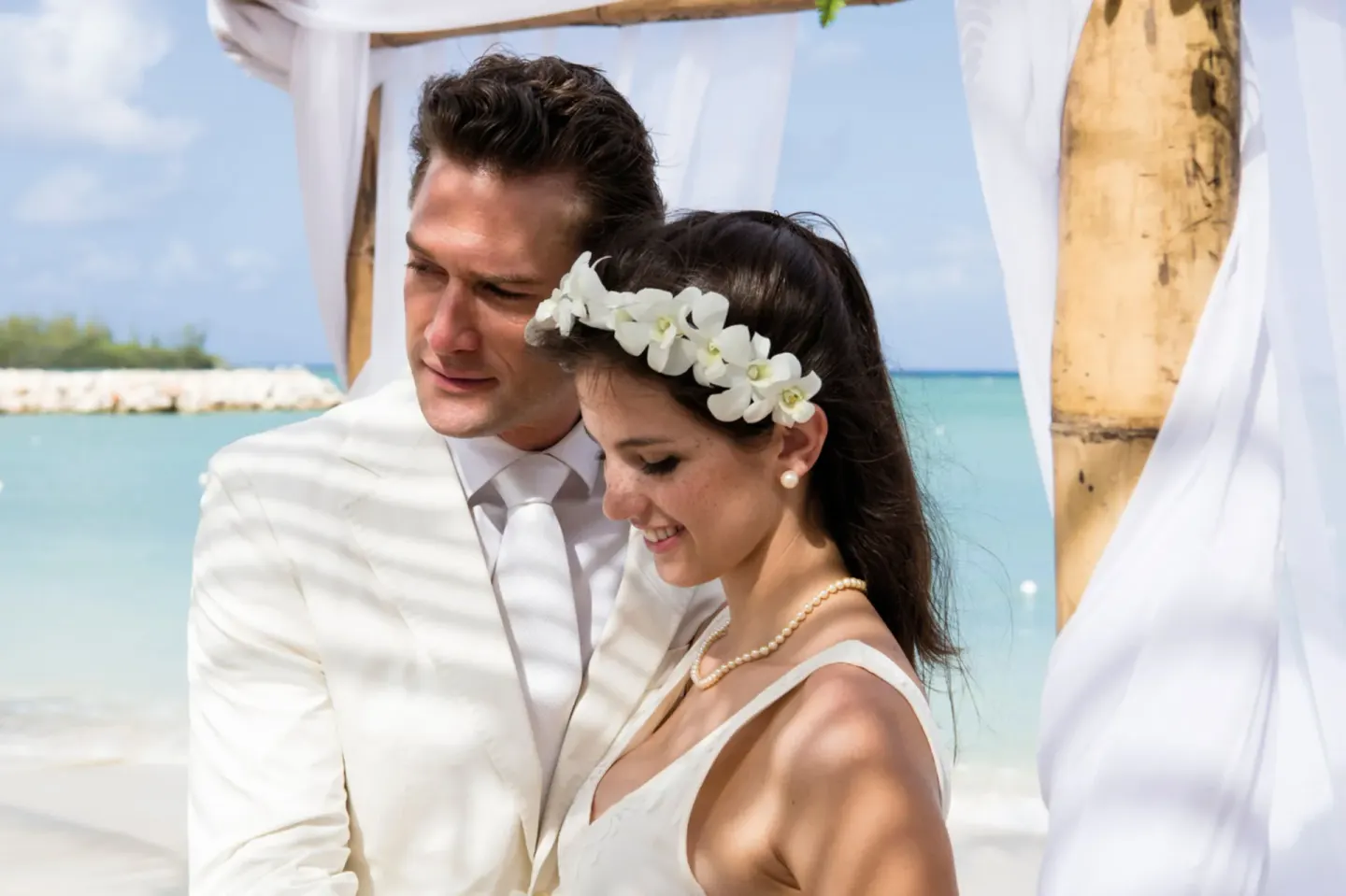 Wedding couple portrait by the beach arch at Hotel Riu Palace Jamaica.