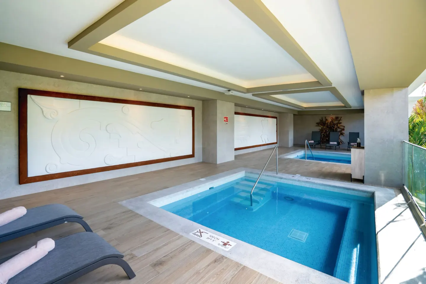 Covered spa hydrotherapy pools with loungers at Hotel Riu Palace Kukulkan.