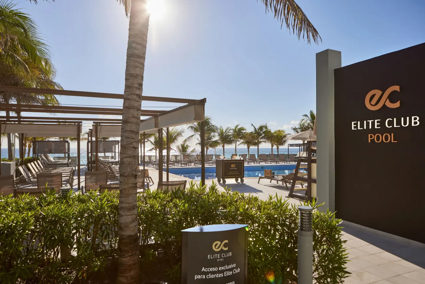 Elite Club pool entrance and oceanfront loungers at Hotel Riu Palace Kukulkan.