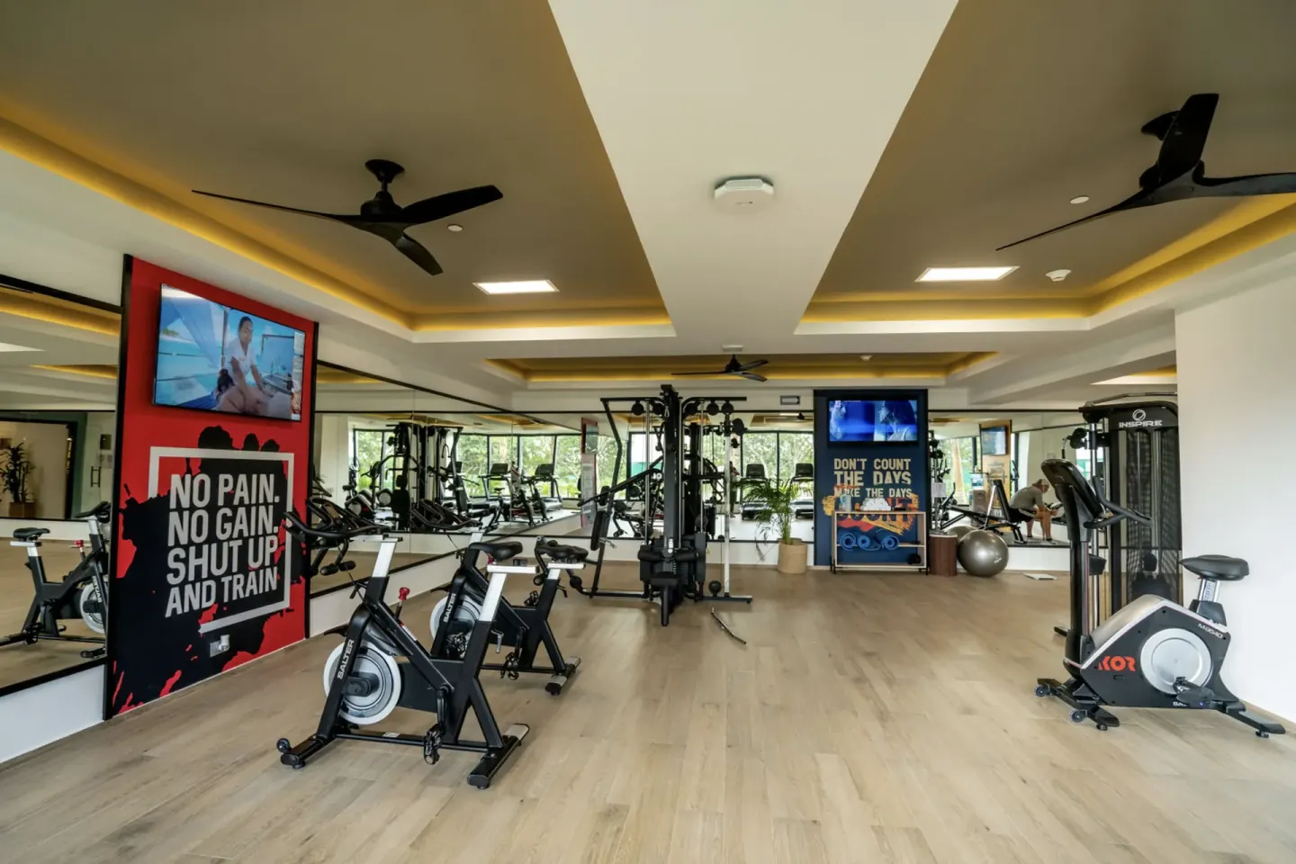 Fitness center with cardio machines and weight equipment at Hotel Riu Palace Kukulkan.
