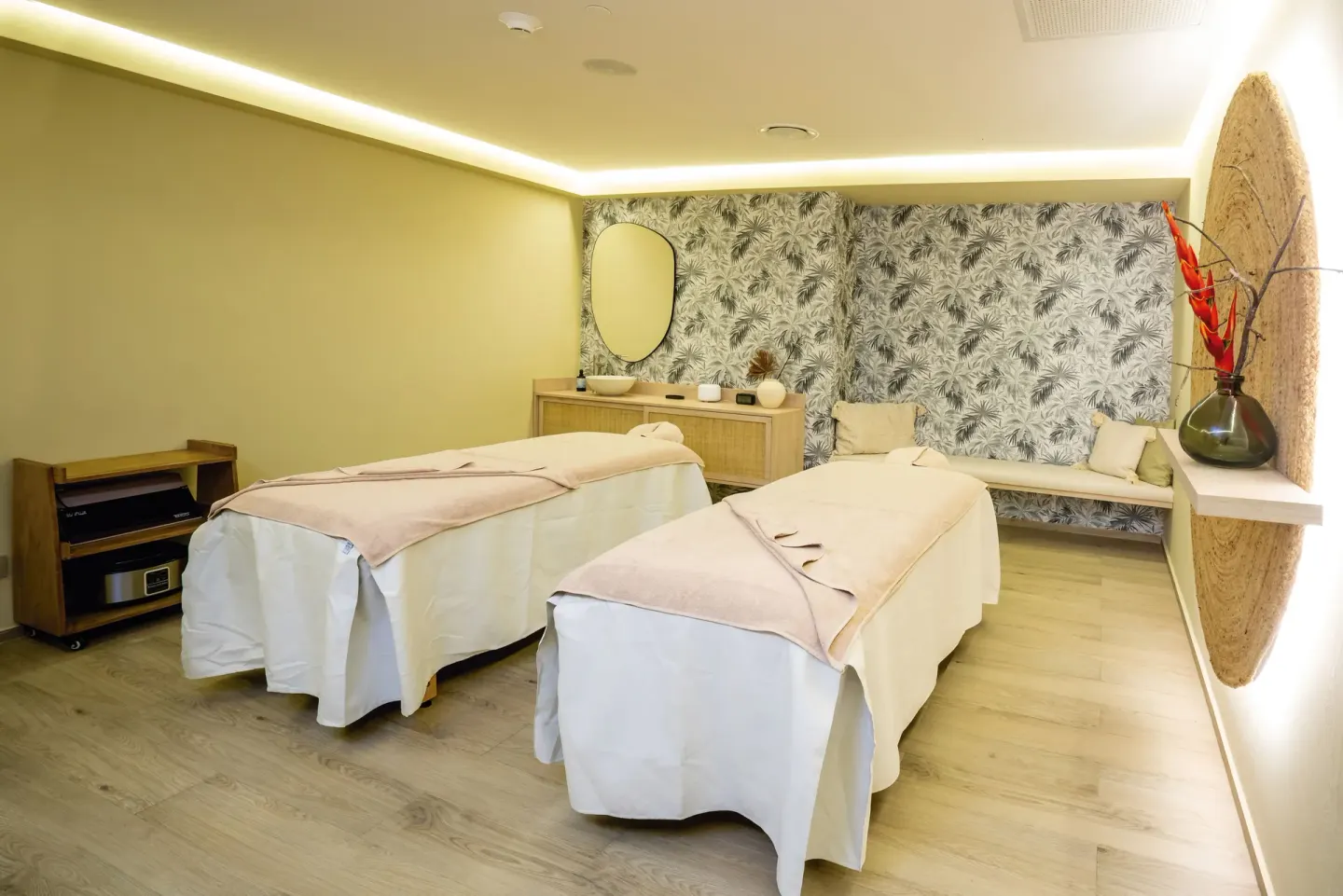 Spa treatment room with twin massage tables and woven wall decor at Hotel Riu Palace Kukulkan.