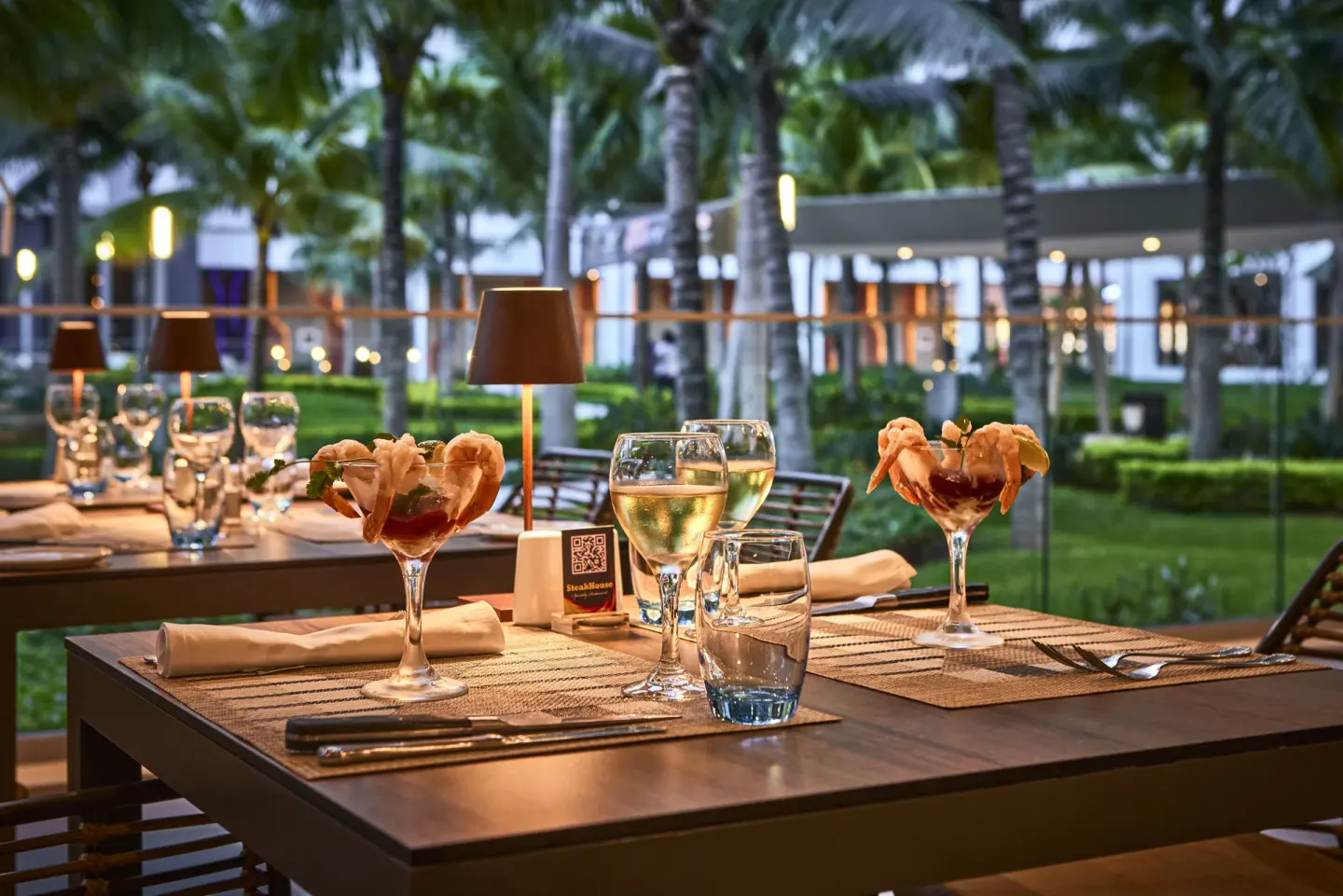 Steakhouse table with shrimp cocktails and wine at Hotel Riu Palace Kukulkan.