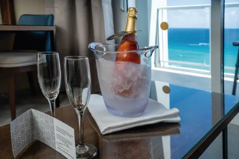 Elite Club Junior Suite Ocean Front welcome bottle and glasses at Hotel Riu Palace Kukulkan.