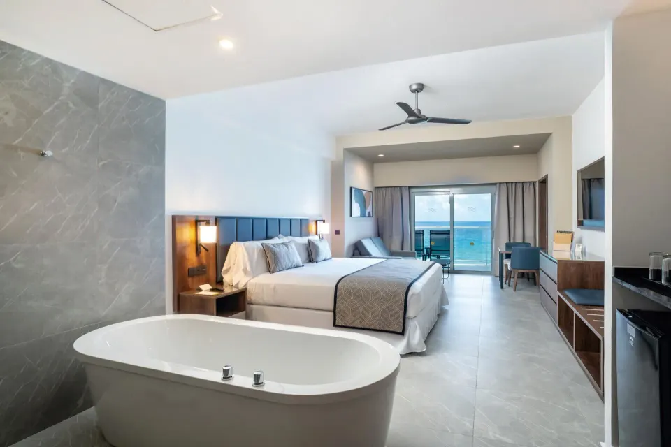 Junior Suite Ocean View with king bed, freestanding tub and balcony at Hotel Riu Palace Kukulkan.