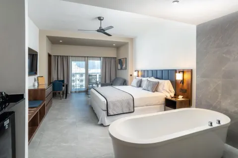 Junior Suite Partial Ocean View with king bed and soaking tub at Hotel Riu Palace Kukulkan.