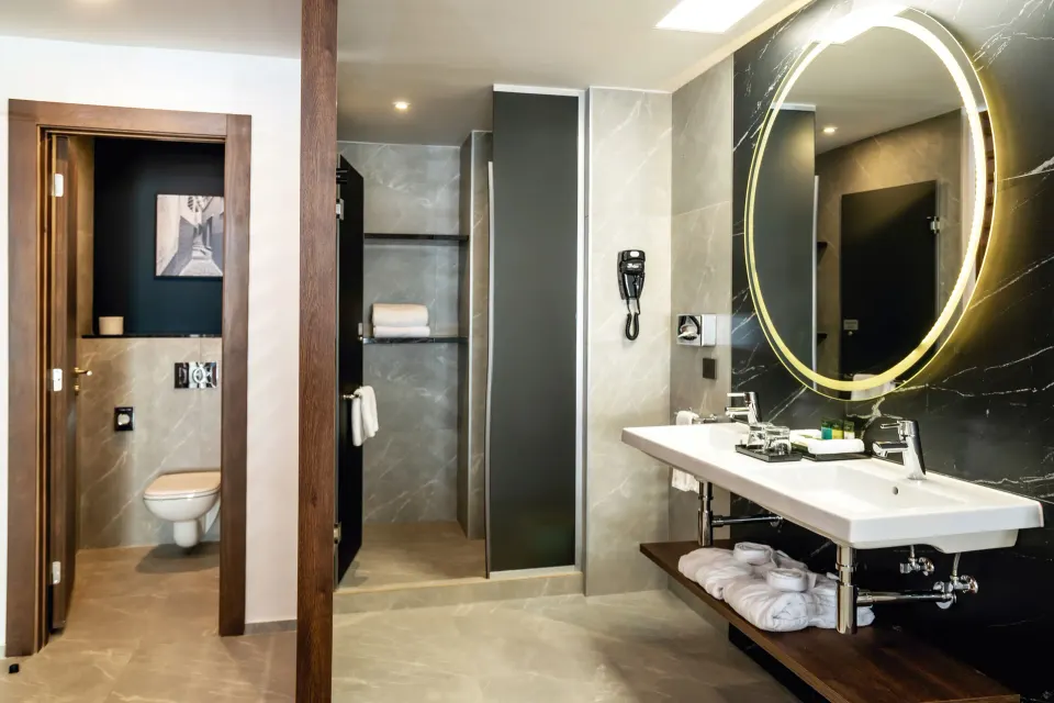 Junior Suite bathroom at Hotel Riu Palace Kukulkan with vanity, shower, and separate toilet area.
