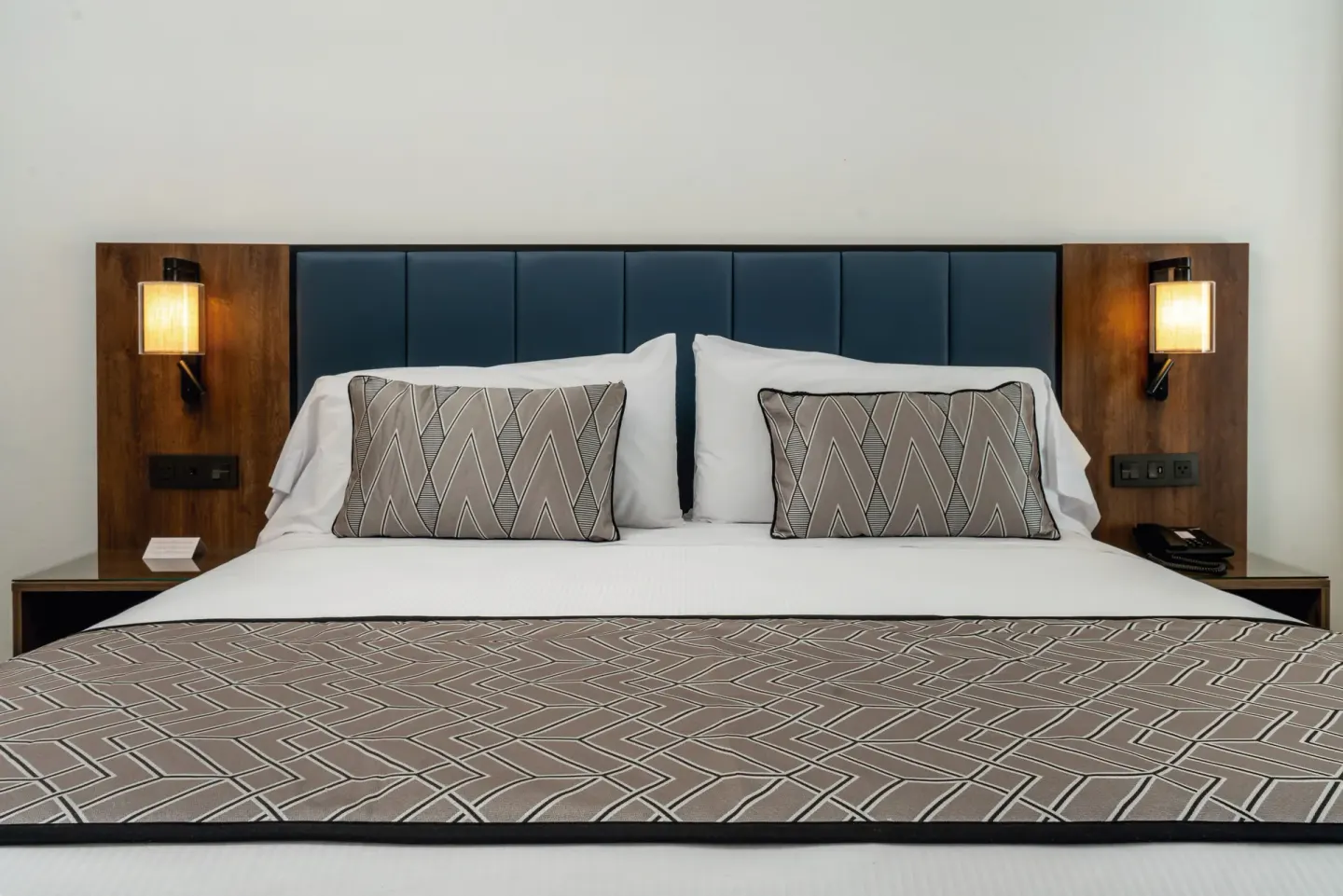 King bed in a Junior Suite at Hotel Riu Palace Kukulkan with blue headboard and wall lamps.