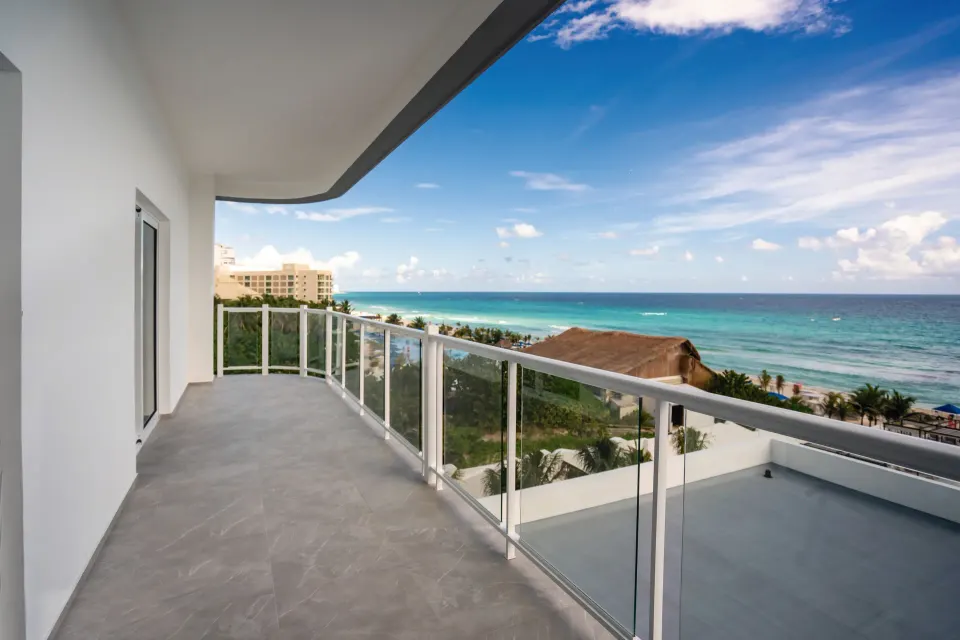 Suite Ocean View Elite Club balcony at Hotel Riu Palace Kukulkan overlooking the turquoise sea.