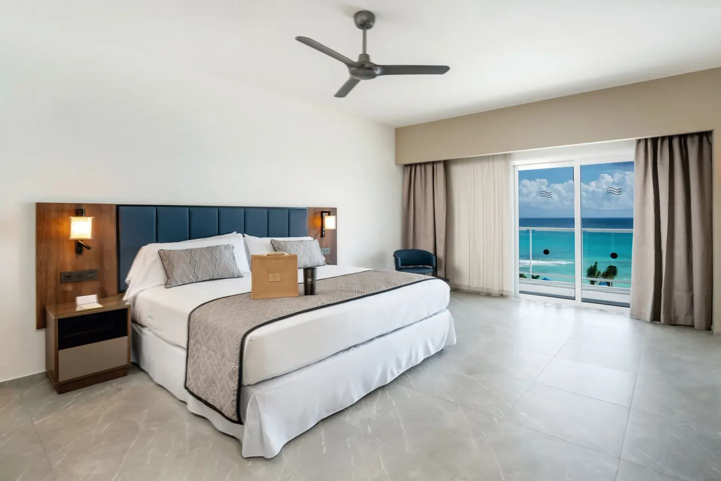 Suite Ocean View Elite Club king bed facing the ocean at Hotel Riu Palace Kukulkan.